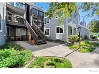 Apartment exterior showcases gray siding, wood balconies, and stair access to the upper units at 12525 E Tennessee Cir # E, Aurora, CO 80012