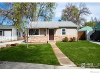 Charming home featuring a stone facade and a well-maintained lawn at 128 E 5Th Ave, Longmont, CO 80504
