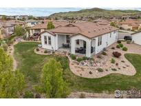 A beautifully landscaped backyard features a covered patio and mountain views at 15156 W Baker W Pl, Lakewood, CO 80228