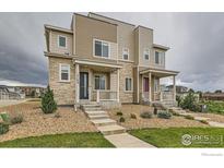 Modern townhome featuring a stone facade, covered entry, and low-maintenance landscaping at 17106 E Alameda Pkwy, Aurora, CO 80017