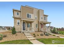 Modern townhouse exterior with stone accents, a covered porch, and well-maintained landscaping at 17106 E Alameda Pkwy, Aurora, CO 80017