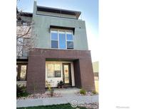 A modern residence featuring a brick facade, a well-kept lawn, and a quaint front porch at 2100 N Clay St, Denver, CO 80211