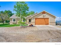 Charming single-story home with a basketball hoop above the attached two-car garage and a well-manicured front lawn at 2212 S County Road 15 Rd, Berthoud, CO 80513