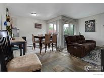 Cozy living room with a brown sofa, dining table, and sliding glass doors for natural light at 3030 Oneal Pkwy # 10, Boulder, CO 80301