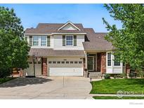 Traditional two-story home with brick accents, a three-car garage, and a well-maintained front yard at 4915 Sage Brush Dr, Broomfield, CO 80023