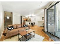 Bright living room features hardwood floors, stylish furnishings, and sliding glass doors to the outside at 5016 Buckingham Rd # 4, Boulder, CO 80301