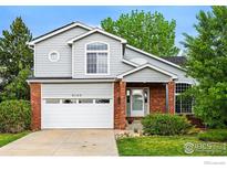 Charming two-story home featuring a brick facade, attached two-car garage, and well-maintained landscaping at 6105 El Diente Cir, Golden, CO 80403