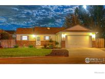 Charming single-story home with a well-maintained lawn, brick accents, and attached two-car garage at 730 Douglas Pl, Berthoud, CO 80513