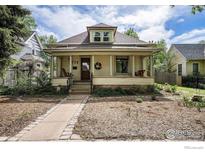 Charming home featuring a quaint front porch, complemented by lush landscaping and a welcoming entrance at 736 Kimbark St, Longmont, CO 80501