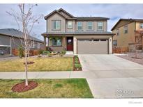 Charming two-story home featuring a covered porch, landscaped yard, and a two-car garage at 890 Eva Peak Dr, Erie, CO 80516