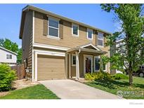 Charming two-story home featuring a well-manicured lawn, attached garage, and inviting front porch at 10667 Durango Pl, Longmont, CO 80504
