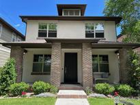 Charming two-story home with brick accents, lush landscaping, and a cozy front porch bench at 1152 S Ogden St, Denver, CO 80210