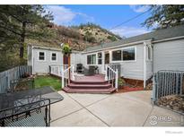 Charming backyard with a multi-level deck, a patio, and views of the surrounding landscape at 159 Virginia Canyon Rd, Idaho Springs, CO 80452