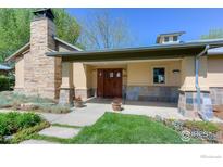 Inviting front entrance with stone accents, a covered porch, and beautifully stained double doors at 23111 County Road 1, Berthoud, CO 80513