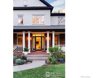 An elegant entry features a brick facade, tall white columns and black trim on the front porch of this beautiful home at 2835 Links Dr, Boulder, CO 80301