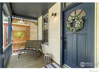 Inviting front porch with a comfortable bench and a stylish blue front door with decorative wreath at 300 E Cleveland St, Lafayette, CO 80026