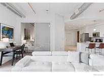 Bright living room features a modern white sofa, office area, and view into the kitchen and bedroom at 3301 Arapahoe Ave # 219, Boulder, CO 80303