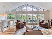 Bright living room features large windows, vaulted ceilings, and hardwood floors at 3410 Heidelberg Dr, Boulder, CO 80305