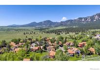 Panoramic aerial view of a cozy neighborhood nestled against a scenic mountain backdrop on a sunny day at 3582 Smuggler Way, Boulder, CO 80305