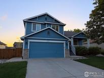 Charming two-story home with blue siding, an attached two-car garage, and inviting curb appeal at 6124 Taylor St, Frederick, CO 80530