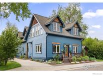 Charming blue two-story home with wood trim and landscaped front yard, inviting curb appeal at 700 Johnson St, Louisville, CO 80027