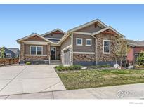 Charming single-Gathering home with stone accents and a well-manicured front yard and a concrete driveway at 874 Quarry Cir, Erie, CO 80516
