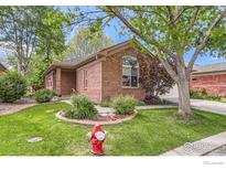 Charming single-story brick home with a well-manicured lawn and lovely landscaping at 1012 Boxelder Cir, Longmont, CO 80503