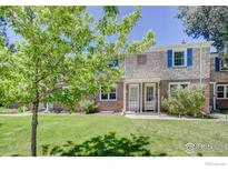 Charming brick townhome featuring a well-maintained lawn and front garden at 1235 Leyden St, Denver, CO 80220