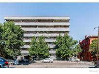 Apartment building with multiple balconies and trees lining the street, creating a welcoming urban oasis at 1441 N Humboldt St # 302, Denver, CO 80218