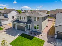 Stunning two-story home with a two-car garage, gray siding, stone accents, and a well-manicured lawn at 16860 Mckay Dr, Mead, CO 80542