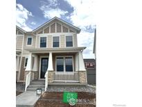 Charming two-story home with neutral colors, welcoming front porch, and well-maintained landscaping at 197 Liberty St, Erie, CO 80516