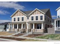 Charming townhome boasts a welcoming front porch and neutral color palette for a warm and inviting appeal at 197 Liberty St, Erie, CO 80516