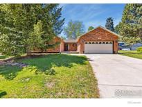 Charming brick home featuring a well-manicured lawn and an attached two-car garage at 2537 Lanyon Dr, Longmont, CO 80503