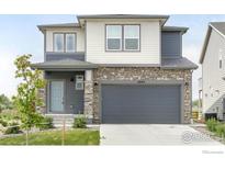 Charming two-story home with a stone facade, gray siding, and a well-manicured lawn at 2905 S Flat Cir, Longmont, CO 80503