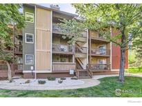 Multi-level condo building featuring private decks and well-maintained landscaping with mature shade trees at 2962 Shadow Creek Dr # 306, Boulder, CO 80303