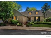 Charming brick home with dormer windows and lush landscaping in a well-manicured yard at 7190 S Poplar Ct, Centennial, CO 80112