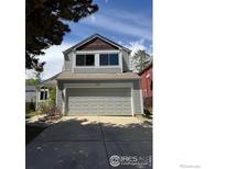 Charming two-story home featuring a grey exterior, attached two-car garage, and well-maintained front yard at 744 Owl Dr, Louisville, CO 80027
