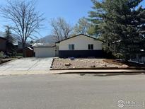 Charming single-Gathering home featuring a well-maintained front yard and a long driveway leading to the attached garage at 1225 Ithaca Dr, Boulder, CO 80305