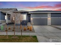 Charming home exterior with well-manicured landscaping and a two-car garage with driveway at 1760 Mount Meeker Ave, Berthoud, CO 80513