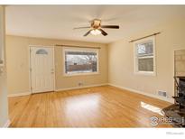 Bright living room featuring hardwood floors, a ceiling fan, and natural light from multiple windows at 503 E Oak St, Lafayette, CO 80026