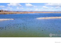 Scenic aerial view of a lake with ducks and distant mountains, perfect for nature lovers at 5425 County Road 32 # 27, Mead, CO 80504