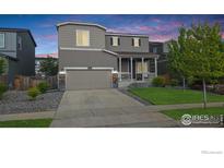 Charming two-story home with a well-maintained lawn and welcoming front porch at 6008 Sandstone Cir, Frederick, CO 80516