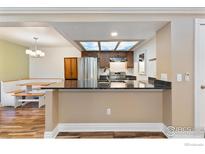 Open-concept kitchen with breakfast bar and eat-in dining area at 10890 W Evans Ave # 1G, Lakewood, CO 80227