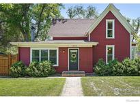 Charming two-story home with red siding, well-maintained landscaping, and a welcoming front entrance at 1245 Longs Peak Ave, Longmont, CO 80501