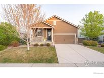 Inviting single-Gathering home showcasing a well-maintained front lawn, a cozy porch, and a two-car garage at 1358 14Th Ave, Longmont, CO 80501