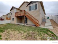 Backyard view showing a wood deck with staircase leading to the yard, and a small concrete patio at 1540 Murrlet St, Berthoud, CO 80513