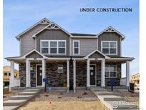 Charming townhome exterior featuring stone accents, covered porches and modern architectural details under construction at 18722 E 99Th Ave, Commerce City, CO 80022