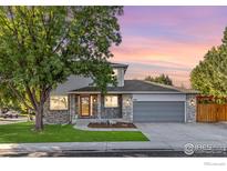 Charming two-story home with a well-manicured lawn, mature trees, and a two-car garage at 2437 Maplewood E Cir, Longmont, CO 80503