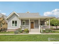 Charming gray home featuring a welcoming front porch, lush landscaping, and a well-manicured lawn at 2917 13Th St, Boulder, CO 80304