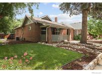 Charming brick home with a covered front porch, landscaped yard, and beautiful curb appeal at 3039 W Denver Pl, Denver, CO 80211